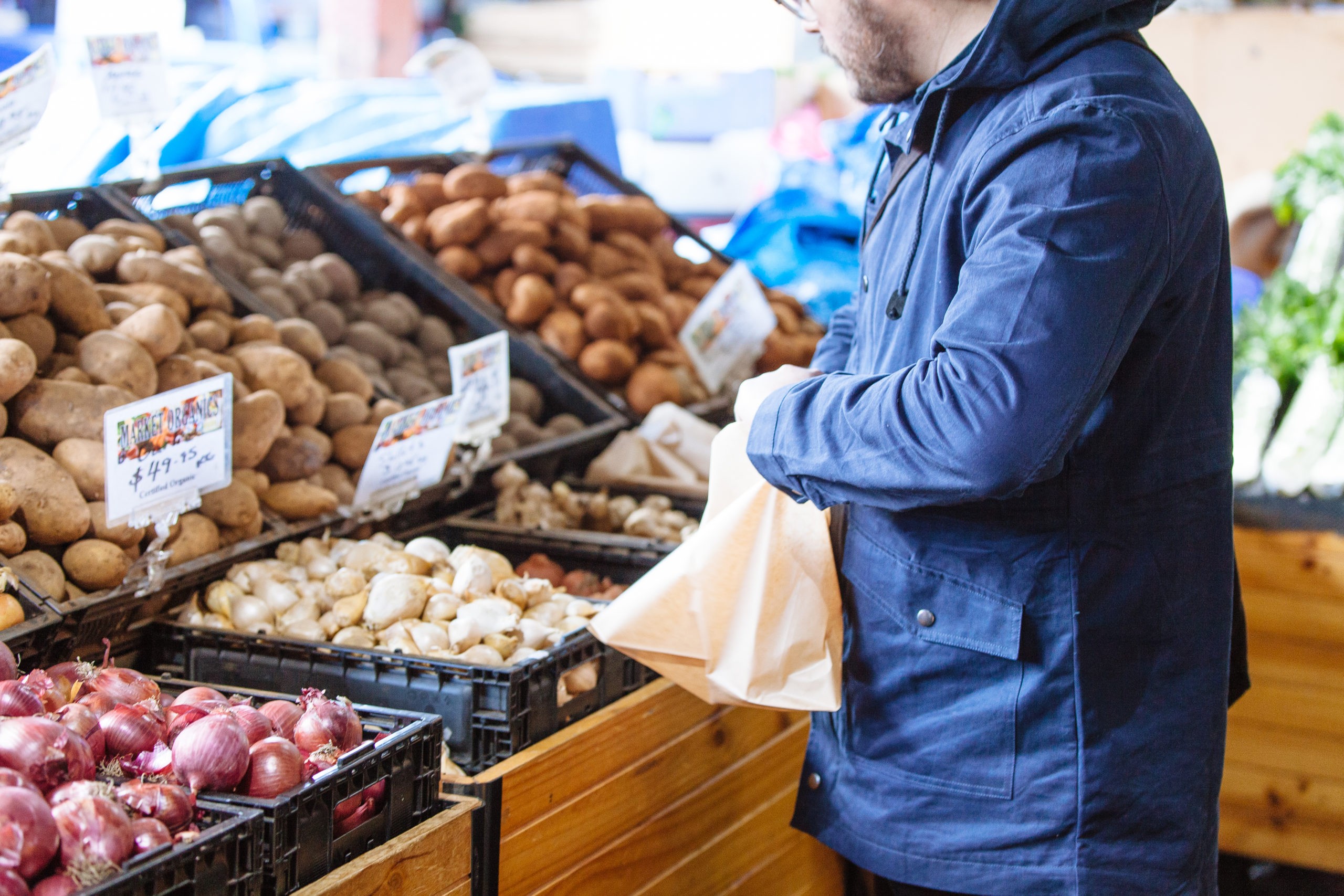 By giving your customers too many options and choice, you may be losing sales. Photo of man choosing fresh produce options, used in blog post by Good Business Consulting about how small businesses can create the right options that lead to purchases.