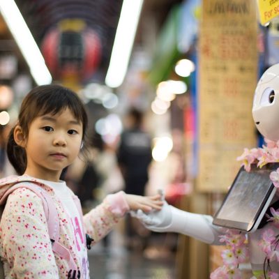 Girl shaking hands with a robot