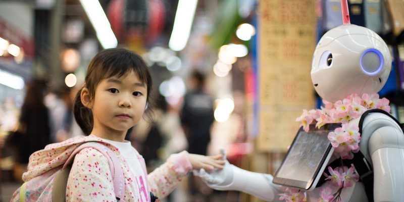 Girl shaking hands with a robot